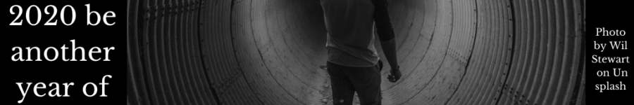 A man looking in fear down a human sized pipe with a flare to light his way.